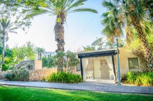 une maison avec un palmier et un garage dans l'établissement Kalia Kibbutz Hotel, à Kalia