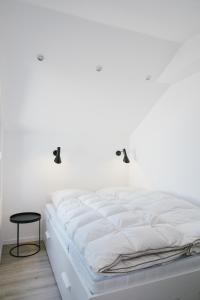 een wit bed in een kamer met een witte muur bij Welcome in - Appartement 'Buena Vista' met een dakterras en berging, dichtbij de pistes in Winterberg