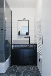 een badkamer met een wastafel en een spiegel aan de muur bij Welcome in - Appartement 'Buena Vista' met een dakterras en berging, dichtbij de pistes in Winterberg