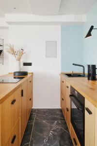 a kitchen with wooden cabinets and a sink at Welcome in - Ferienwohnung 'Buena Vista' mit Dachterrasse und Abstellraum, in der Nähe der Pisten in Winterberg