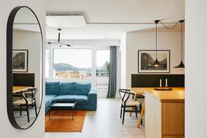 a living room and dining room with a blue couch at Welcome in - Ferienwohnung 'Buena Vista' mit Dachterrasse und Abstellraum, in der Nähe der Pisten in Winterberg