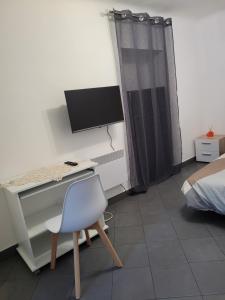 escritorio con ordenador y silla en una habitación en Appartement Moulinet, en Moulinet