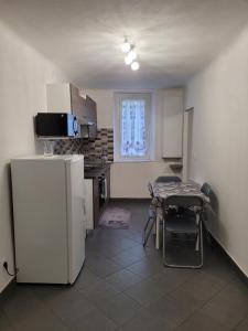una pequeña cocina con mesa y nevera en Appartement Moulinet, en Moulinet