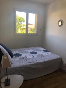 een bed in een kamer met een raam bij Villa 3 pièces avec jacuzzi privé in Pérols