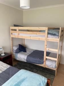 two bunk beds in a room with a bed at Bruny Ocean Cottage in Alonnah