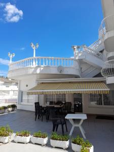 Un balcón con una mesa y sillas en un edificio. en Apartamentos Las Americas - Blanes Beach, en Blanes