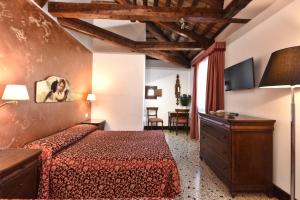 pokój hotelowy z łóżkiem i telewizorem w obiekcie Locanda Casa Martini w Wenecji