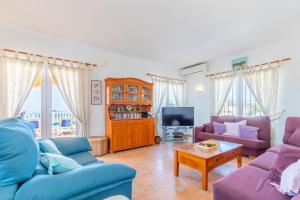 een woonkamer met 2 banken en een tv bij Casa Maravilla in Benitachell