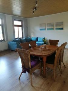 a living room with a wooden table and a blue couch at Ferienwohnung Landoase in Kollerup