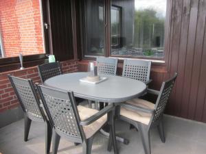 - une table et des chaises sur une terrasse couverte avec une bougie dans l'établissement Ferienwohnung Landoase, à Kollerup
