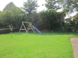 a playground in a yard with a slide at Landoase - große Ferienwohnung mit toller Ausstattung, überdachter Terrasse und Garten in Kollerup
