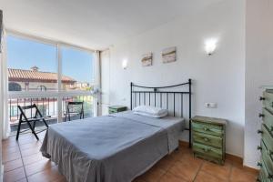 a bedroom with a bed and a large window at Apartment Fuengirola City Station in Fuengirola