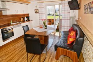 a kitchen and living room with a table and a couch at Haus Gabriela in Itter