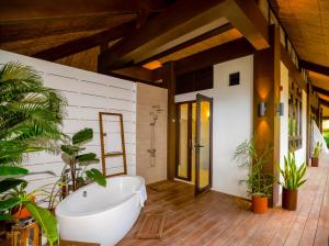 a bathroom with a tub and plants in it at LIHIM RESORTS in El Nido
