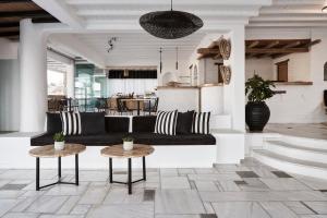 a living room with a black couch and two tables at Mr & Mrs White Mykonos in Platis Gialos