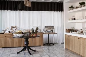 a kitchen with a table with a bowl of fruit on it at Mr & Mrs White Mykonos in Platis Gialos