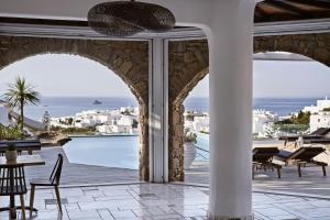 an outdoor patio with a view of the ocean at Mr & Mrs White Mykonos in Platis Gialos