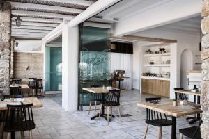 a restaurant with tables and chairs in a room at Mr & Mrs White Mykonos in Platis Gialos