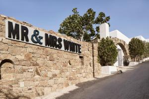 a stone wall with a sign that reads mr and mms unite at Mr & Mrs White Mykonos in Platis Gialos