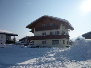 ein schneebedecktes Haus mit einem Schneehaufen in der Unterkunft Haus Gabriela in Itter