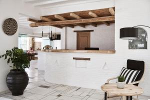 a room with a bar and a chair and a table at Mr & Mrs White Mykonos in Platis Gialos