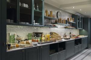 a kitchen with a counter with food and drinks at Petit Palace Puerta de Triana in Seville