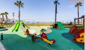 um parque infantil na praia com escorrega e um parque de skate em Apartamento SIDI Resort de lujo en Playa San Juan em Alicante