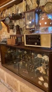 una vitrina de cristal con radio y otros artículos en Guest House Antique, en Nazaret