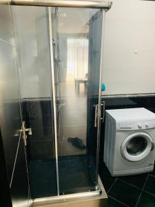 a shower with a washing machine in a bathroom at Batumi Center 3 Rooms City Side in Batumi