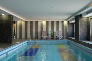 a swimming pool with two chairs next to a building at Gorash Hotel in Khamis Mushayt