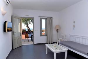 una camera con letto, tavolo e porta di Villa Mare Angelica a Perivolos