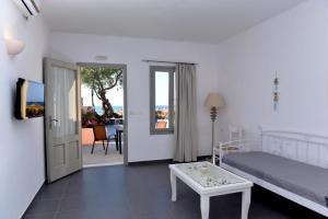 a bedroom with a bed and a table and a door at Villa Mare Angelica in Perivolos