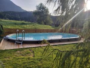 a swimming pool on a wooden deck in a yard at Alpenresidenz Ötztal in Oetz