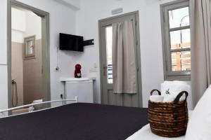 a bedroom with a bed and a window and a television at Villa Mare Angelica in Perivolos +36 photos