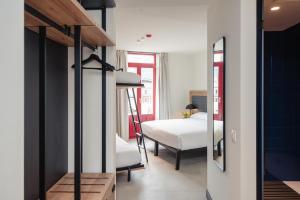 Habitación con cama y dormitorio con espejo. en LATROUPE La Granja, en Bilbao