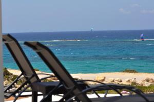 two lawn chairs sitting on a beach with the ocean at Kyanis Villa , Karpathos Afiartis in Afiartis