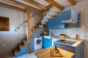 eine Küche mit blauen Schränken, einer Waschmaschine und einem Trockner in der Unterkunft Samis Pelion LuxuryLiving in Portaria