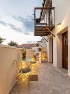 patio ze stołem i krzesłami oraz balkonem w obiekcie Samis Pelion LuxuryLiving w mieście Portariá