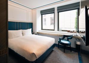 a bedroom with a bed and a desk and windows at Page8, Page Hotels in London