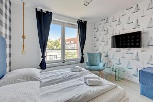 a bedroom with a bed and a tv and a chair at Grand Apartments - Tartaczna Sailor Studio Gdańsk in Gdańsk