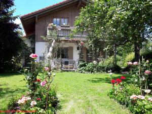 dom z ogrodem z kwiatami przed nim w obiekcie Ferienhaus Graziadei w mieście Grassau