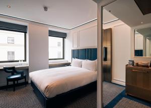 a bedroom with a bed and a desk and a mirror at Page8, Page Hotels in London