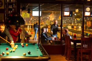 een groep mensen die pool spelen in een bar bij Hotel Café Restaurant De Ploeg in Varsseveld