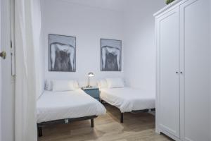 バルセロナにあるThe White Flats Eixampleの白い壁の客室内のベッド2台