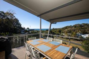 a table on a balcony with a view of the ocean at THE LOOKOUT BEACH HOUSE in Point Lookout