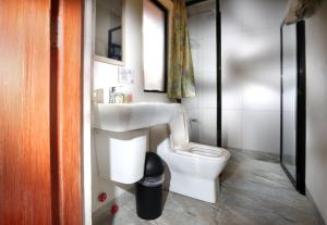 a bathroom with a white toilet and a sink at 1775 Adriatico Suites in Manila