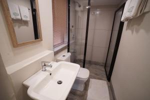 a white bathroom with a sink and a toilet at 1775 Adriatico Suites in Manila