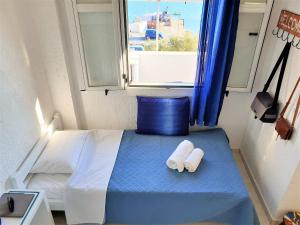 a bedroom with a bed and a window with towels at The eagle in Kali Limenes