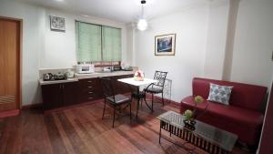 a living room with a red couch and a table at 1775 Adriatico Suites in Manila