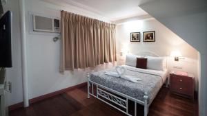 a bedroom with a bed and a window at 1775 Adriatico Suites in Manila